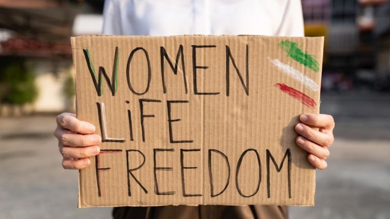 Person holding a sign saying Woman Life Freedom.