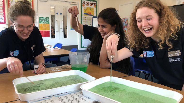 Three DPhil student volunteers from the MRC WIMM playing with slime at Freeland CE Primary School. From left to right: Grace Meaker (Wilkinson group); Norah Alrishedan (Bodmer group); Maya Pidoux (Dong group).